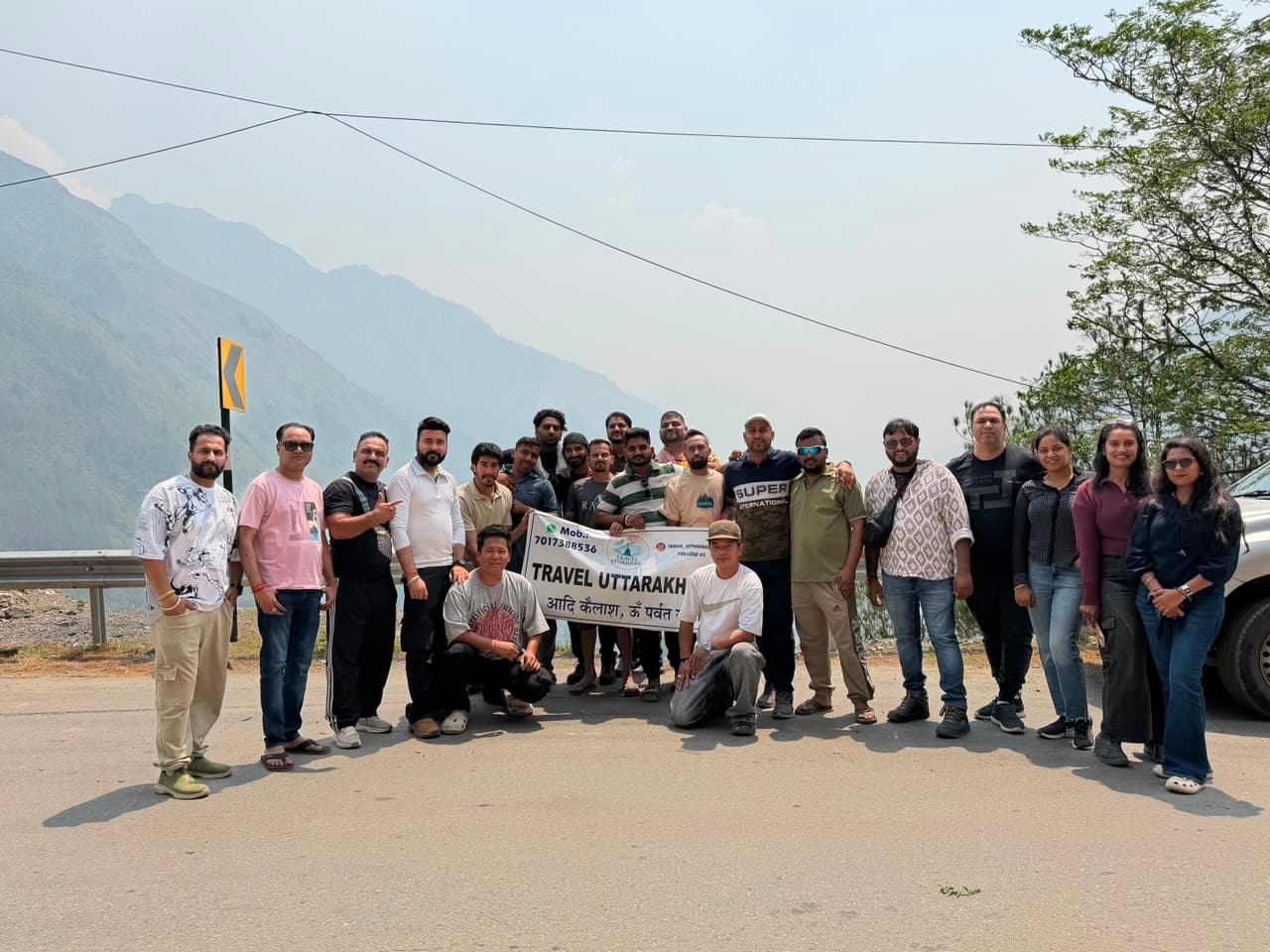 Large group of yatris on the mountain road with prayer flags
